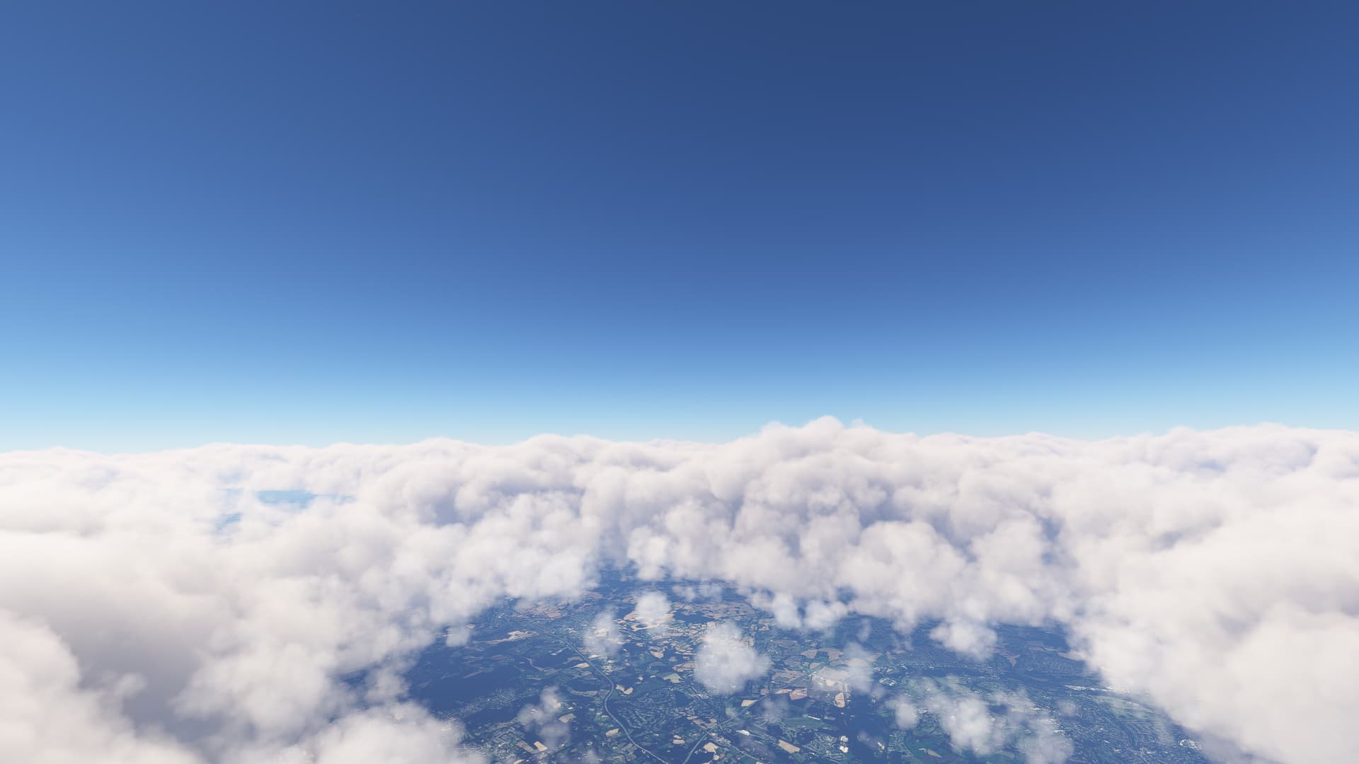 Aerial view of clouds and landscape from high altitude in Microsoft Flight Simulator 2024