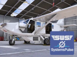 The GA-8 Airvan parked in the hangar with all doors opened and covers installed for a preflight inspection. SystemsPulse logo in the corner.